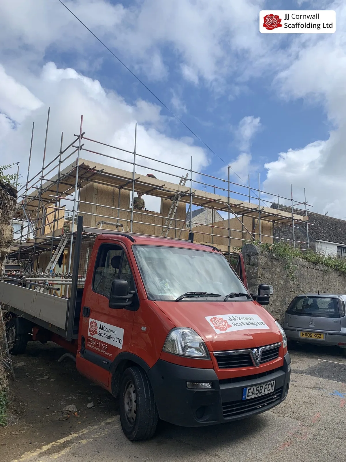 JJ Cornwall Scaffolding: red branded tipper at a scaffolded house