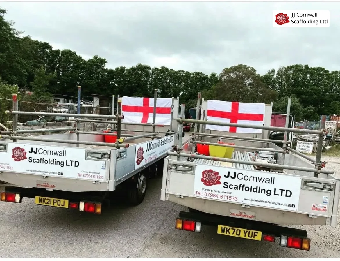 JJ Cornwall Scaffolding: two branded tippers rear view with england flags flown on the scaffold