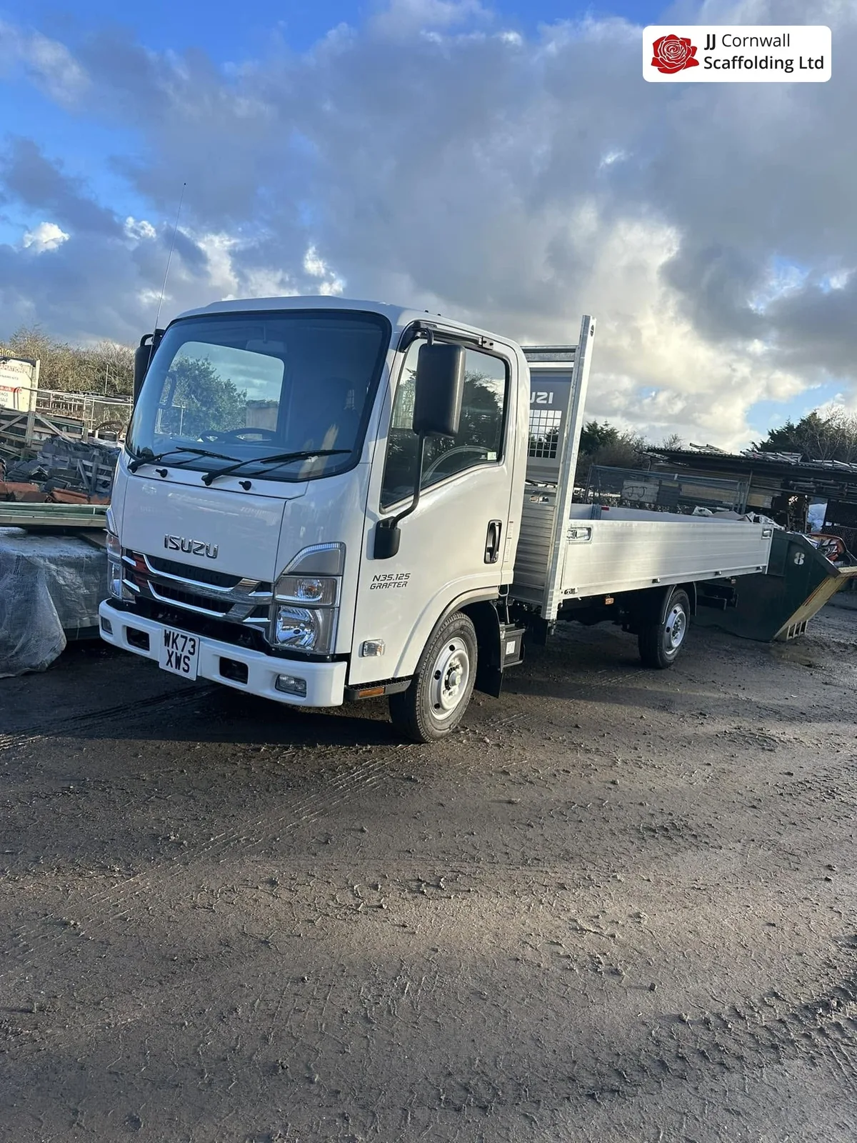 JJ Cornwall Scaffolding: white branded isuzu dropside tipper in the yard