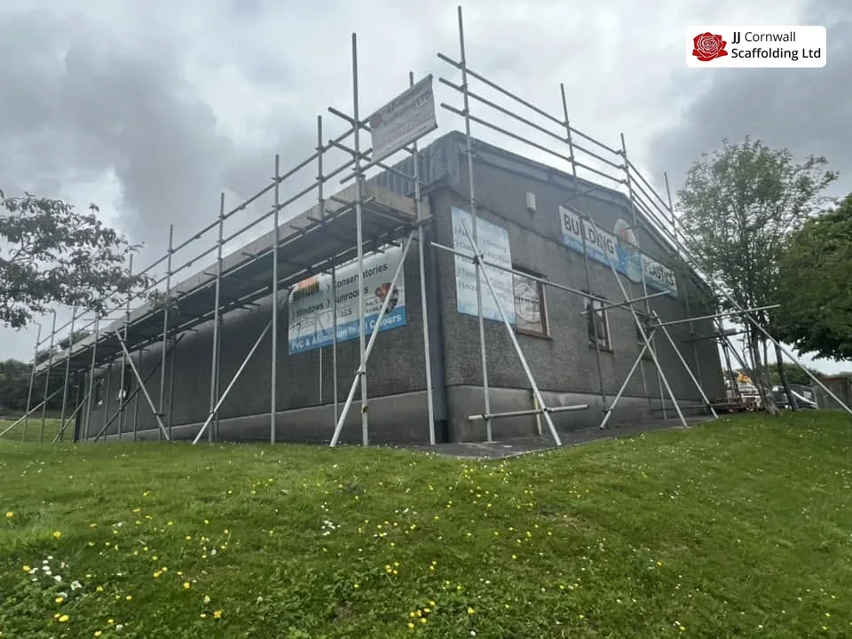 Commercial scaffolding in Cornwall: grey clad unit roof edge scaffold over open grass
