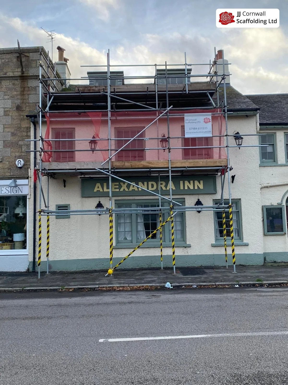 Commercial scaffolding in Cornwall: village pub inn frontage red netted lift from the road