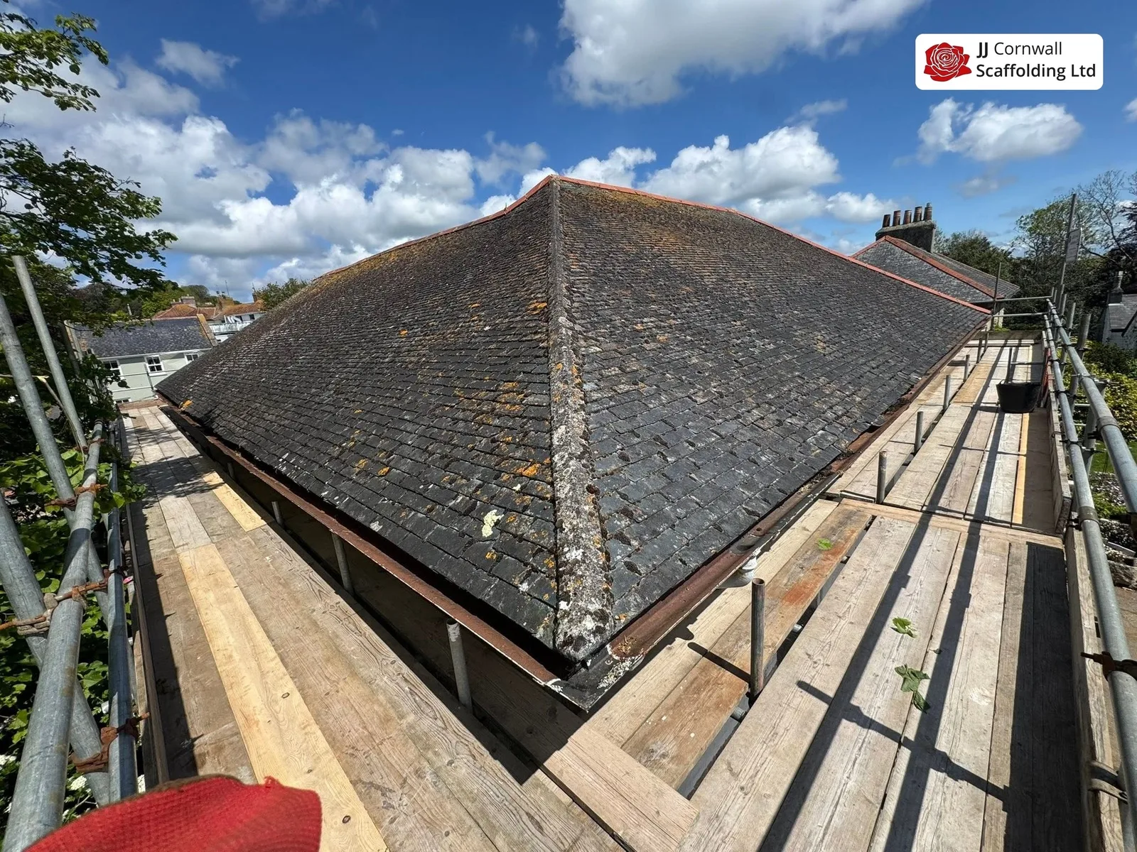 Domestic scaffolding in Cornwall: boarded run around a hipped slate roof