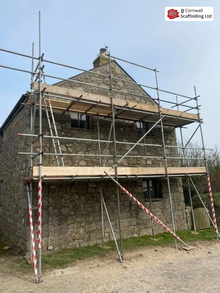 Domestic scaffolding in Cornwall: granite barn independent scaffold with barriers on open ground