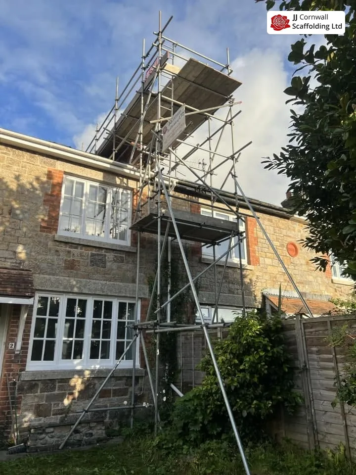 Domestic scaffolding in Cornwall: granite house bay window scaffold with loading deck above