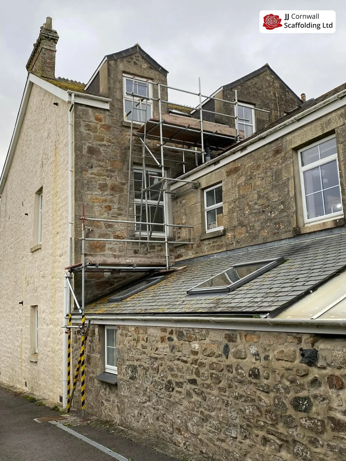 Domestic scaffolding in Cornwall: granite house with dormers scaffold over a slate lean to roof
