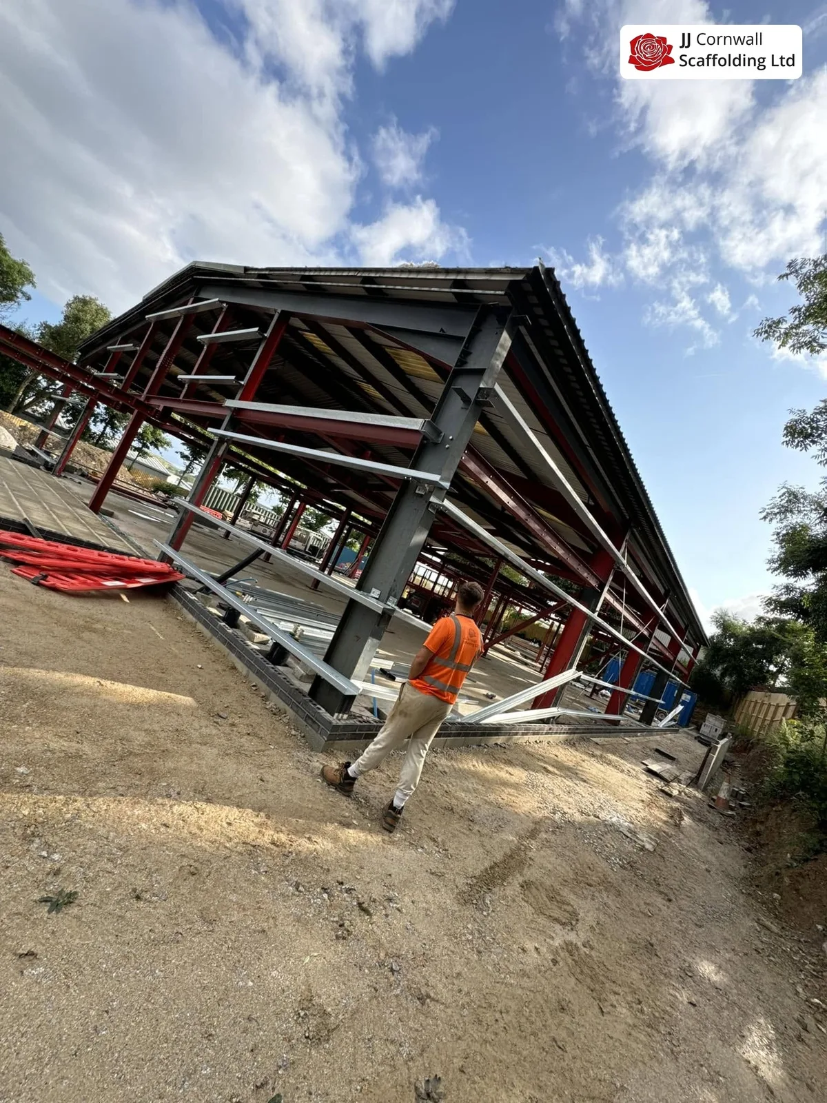 Domestic scaffolding in Cornwall: steel framed open structure under construction with operative