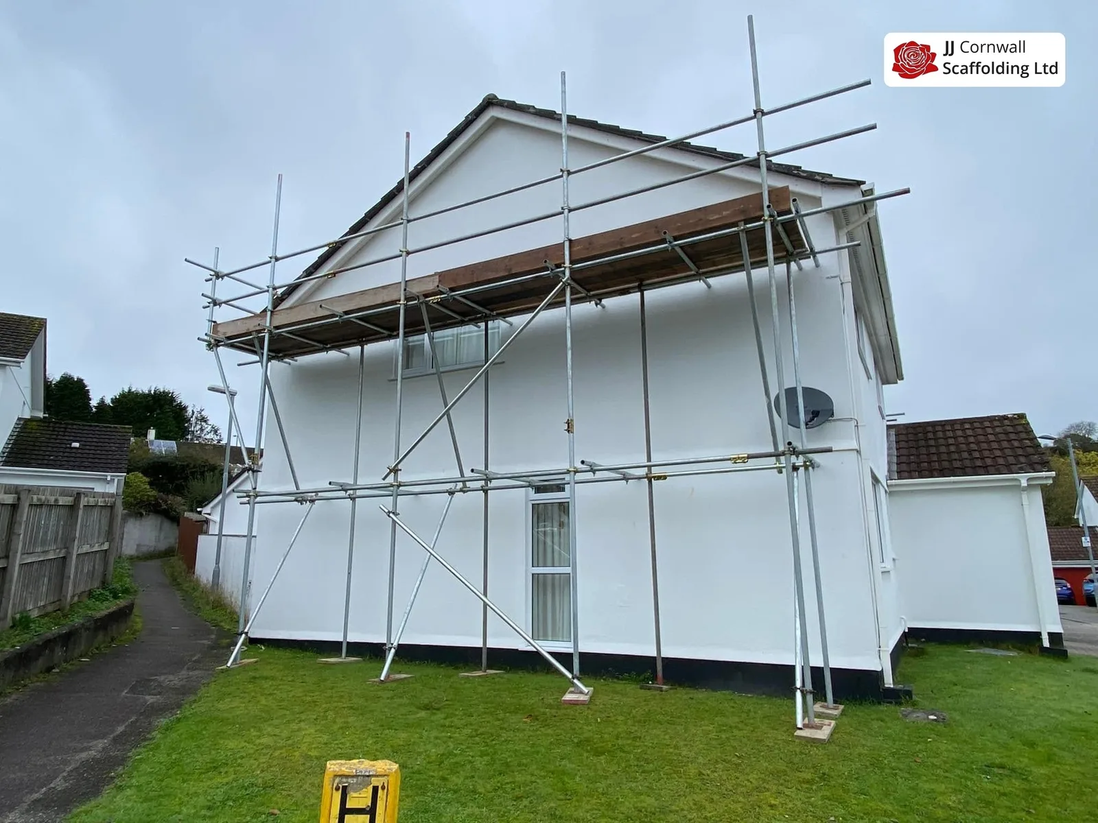 Domestic scaffolding in Cornwall: white rendered bungalow gable scaffold across the lawn