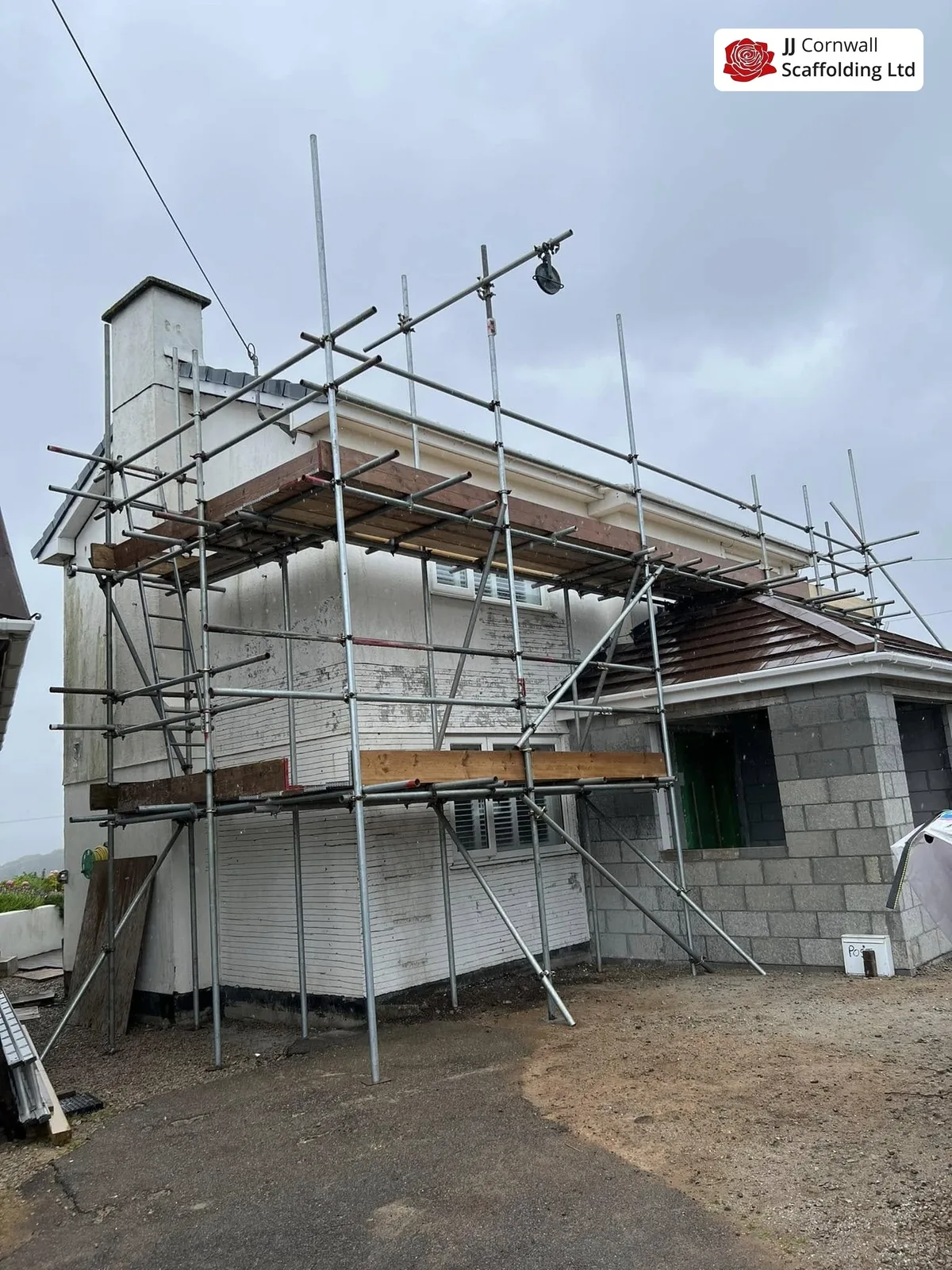 Domestic scaffolding in Cornwall: white rendered extension scaffold over new blockwork