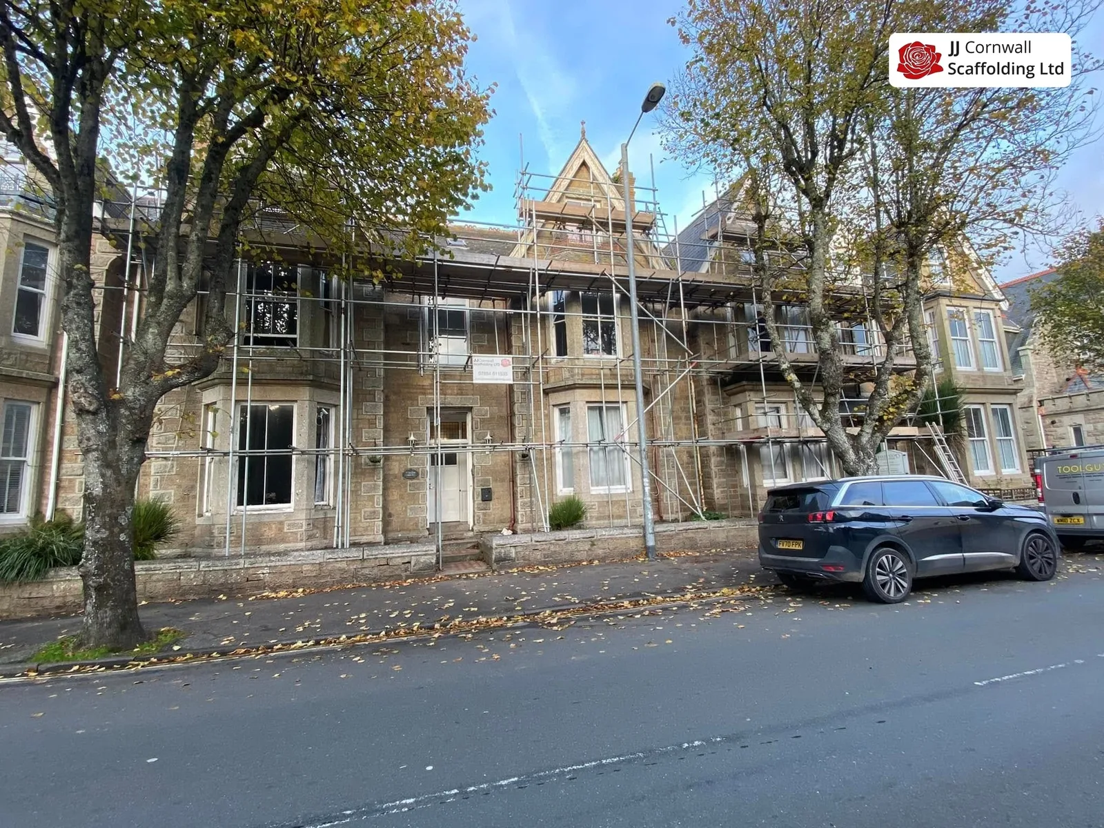 Heritage scaffolding in Cornwall: long victorian frontage scaffold under autumn trees