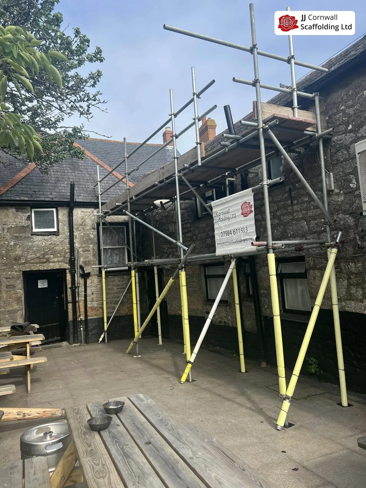 Scaffold hire in Cornwall: adjustable steel props and scaffold against a granite building