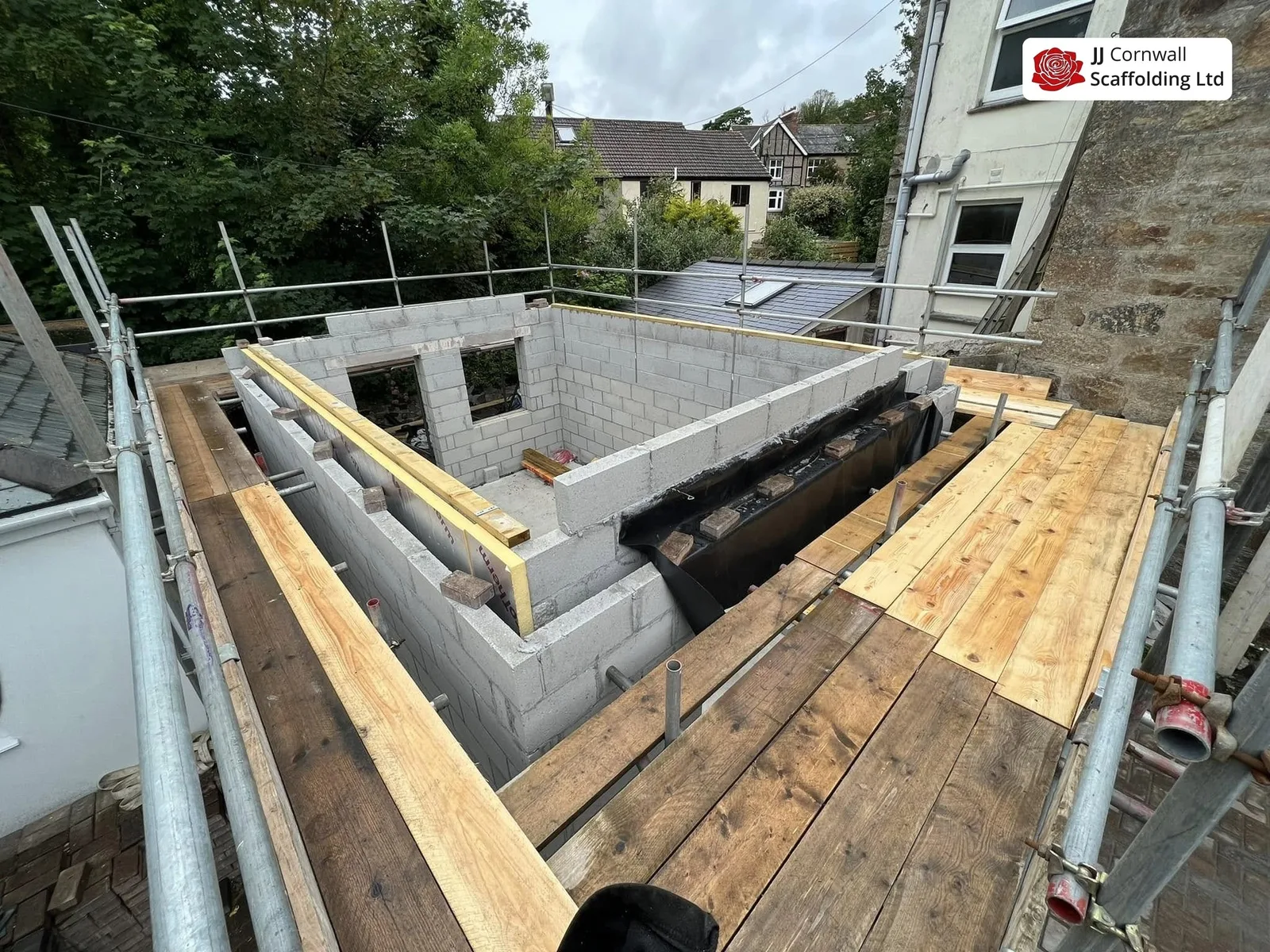 Scaffold hire in Cornwall: boarded deck over a blockwork extension shell with new joists