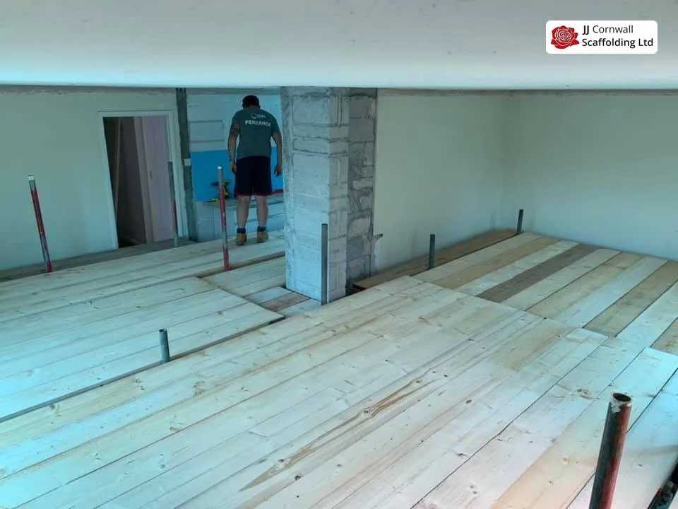 Scaffold hire in Cornwall: internal boarded deck and handrail with operative at the doorway