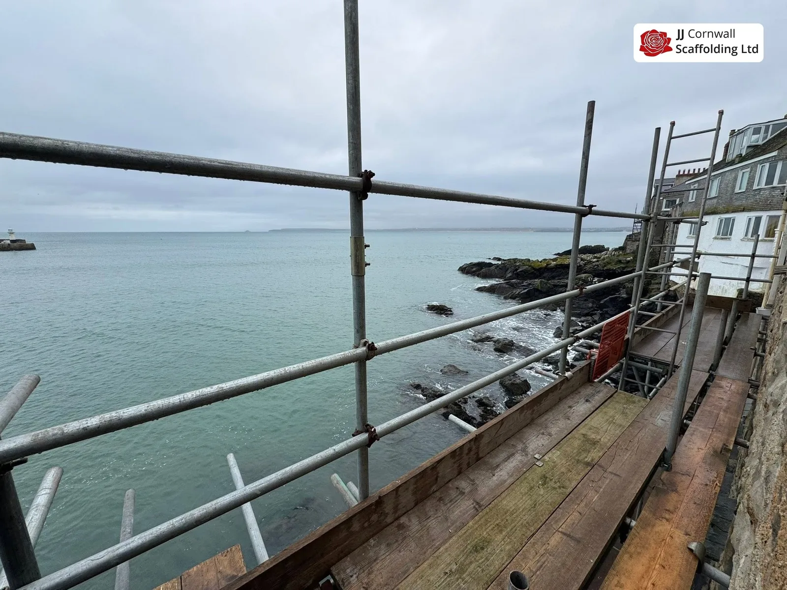 Scaffold hire in Cornwall: sea facing deck looking along the rocks toward town